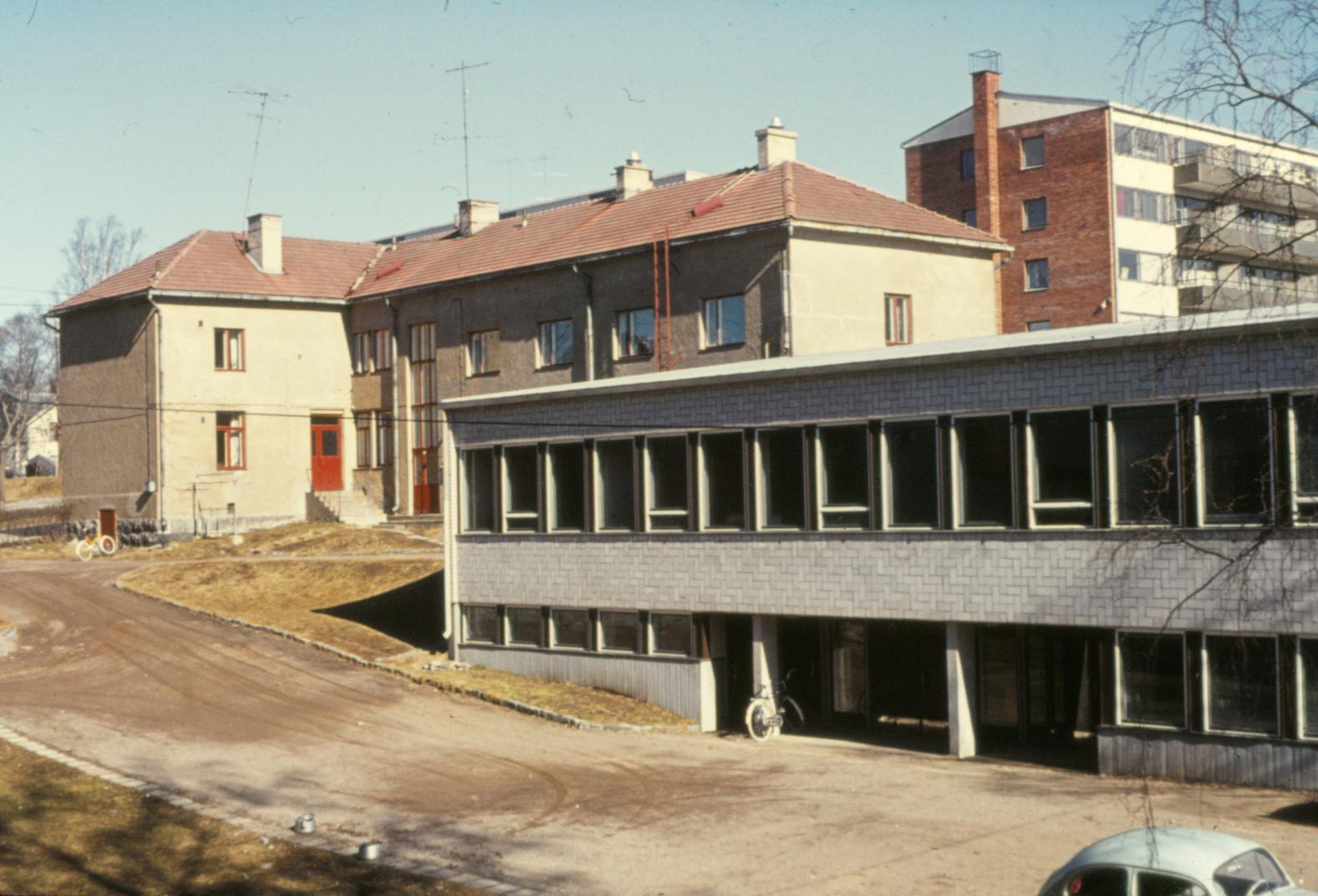 Det gamla huset med personalbostäder och pojkinternat uppe i backen och nedanför verkstadsbyggnaden från 1963.